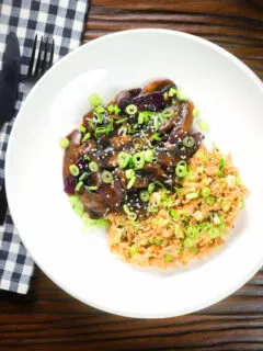 Overhead teriyaki mushrooms stir fry served with egg fried rice and spring onions.