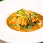 Thai red curry vegetable soup with coconut milk, cauliflower and sugar snap peas.