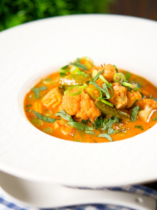 Thai red curry vegetable soup with coconut milk, cauliflower and sugar snap peas.