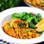 Vegetarian vegetable paella with fennel and artichokes served with a side salad.