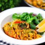 Vegetarian vegetable paella with fennel and artichokes served with a side salad.