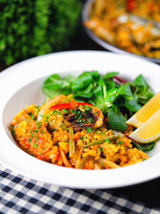 Vegetarian vegetable paella with fennel and artichokes served with a side salad.