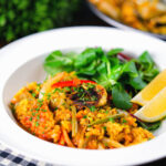 Vegetarian vegetable paella with fennel and artichokes served with a side salad.