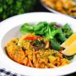 Vegetarian vegetable paella with fennel and artichokes served with a side salad.