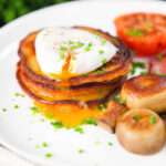 Irish boxty potato pancakes with poached egg, mushrooms and grilled tomato.