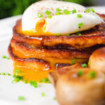 Close-up Irish boxty potato pancakes with poached egg and mushrooms.