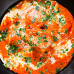 Overhead close-up rich and creamy Indian butter chicken curry or murgh makhani.