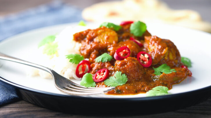 Indian sweet and sour chicken pathia curry served with white rice, chilli and coriander.