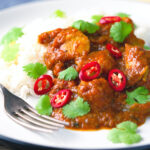 Hot, sweet and sour Indian chicken pathia curry with rice and coriander.