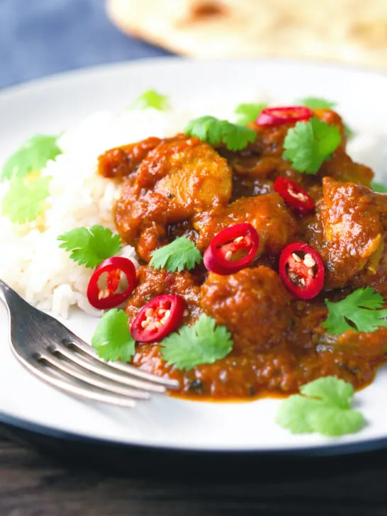 Hot, sweet and sour Indian chicken pathia curry with rice and coriander.