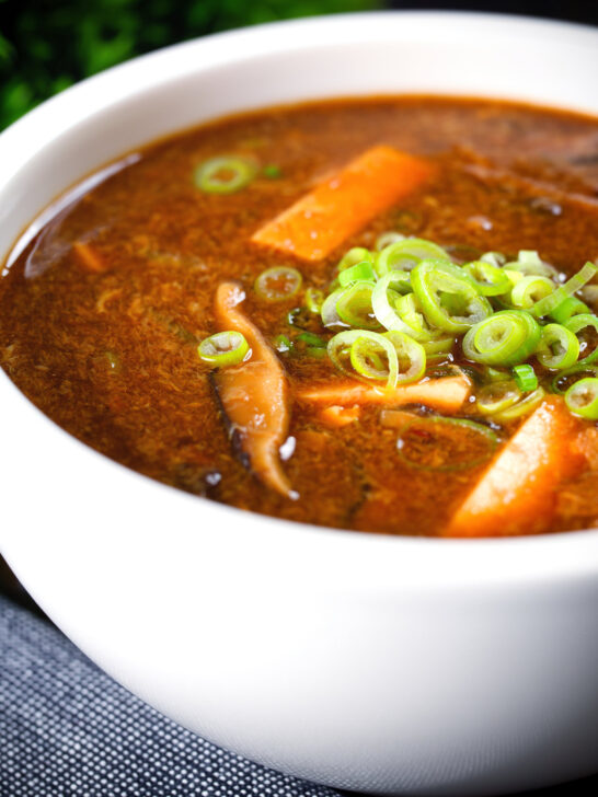 Close-up vegetarian Chinese hot and sour soup garnished with spring onions.