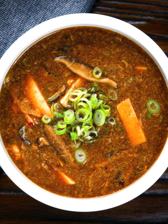 Close-up overhead vegetarian Chinese hot and sour soup garnished with spring onions.