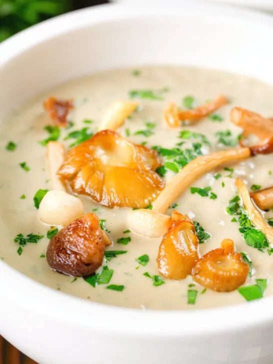 Close-up creamy wild mushroom soup garnished with fried mushrooms.