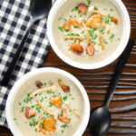 Overhead creamy wild mushroom soup garnished with fried mushrooms.