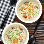 Overhead creamy wild mushroom soup garnished with fried mushrooms.