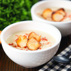 Cream of Jerusalem artichoke soup garnished with sweet paprika and sunchoke crisps.