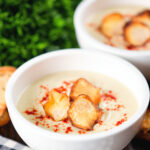 Creamy Jerusalem artichoke soup garnished with paprika and fried sunchoke crisps.