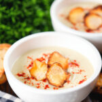 Creamy Jerusalem artichoke soup garnished with paprika and fried sunchoke crisps.
