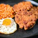 Crispy canned corned beef fritters with fried egg and beans.