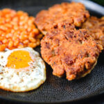 Crispy canned corned beef fritters with fried egg and beans.