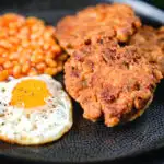 Crispy canned corned beef fritters with fried egg and beans.