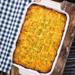 Overhead haggis shepherds pie with clapshot (swede and potato mash) in a baking dish.