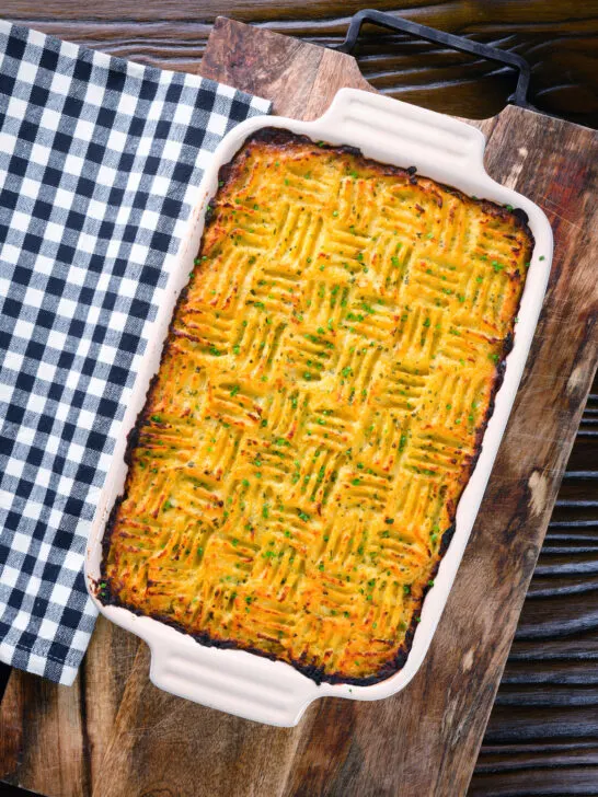 Overhead haggis shepherds pie with clapshot (swede and potato mash) in a baking dish.