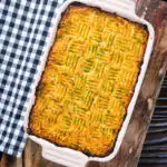 Overhead haggis shepherds pie with clapshot (swede and potato mash) in a baking dish.