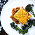 Overhead haggis shepherds pie with clapshot (swede and potato mash) server with broccoli.