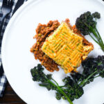 Overhead haggis shepherds pie with clapshot (swede and potato mash) server with broccoli.