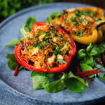 Baked stuffed peppers with halloumi cheese, brown rice, harissa pasta and raisins.