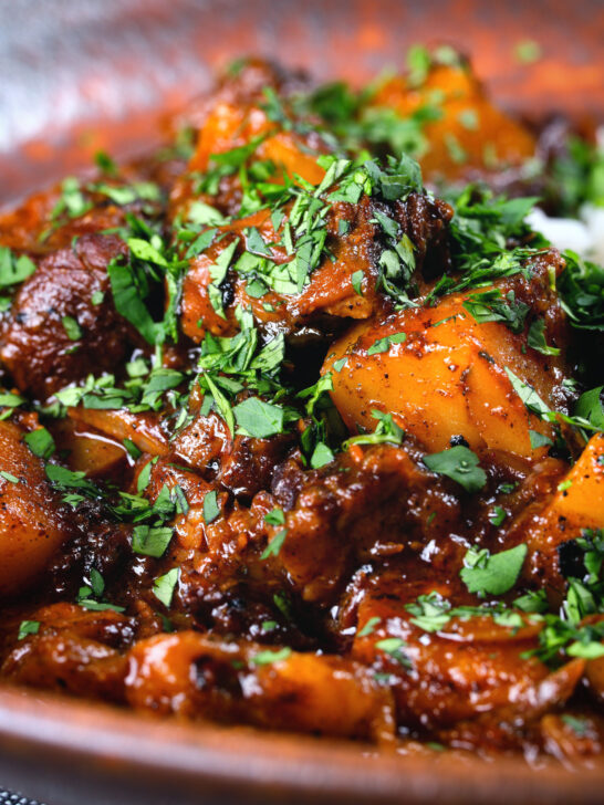 Close-up Indian potato and oxtail curry served with rice.