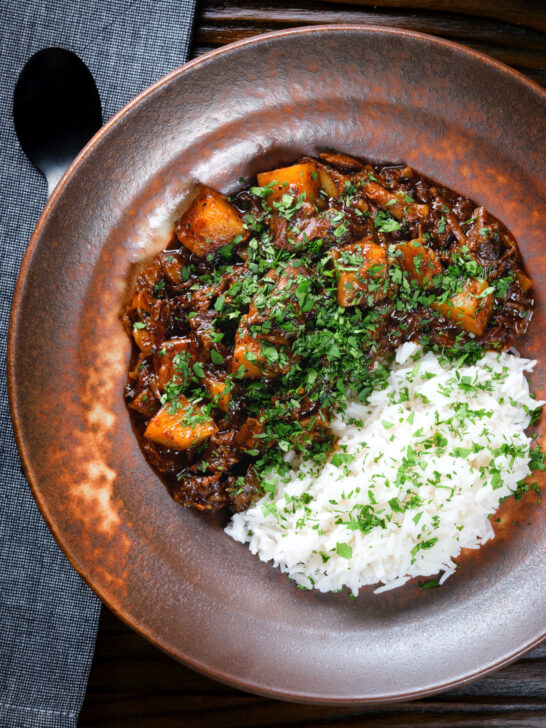 Overhead Indian potato and oxtail curry "stew" served with rice.