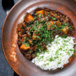 Overhead Indian potato and oxtail curry "stew" served with rice.