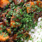 Overhead close-up Indian potato and oxtail curry served with rice.