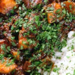 Overhead close-up Indian potato and oxtail curry served with rice.