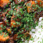 Overhead close-up Indian potato and oxtail curry served with rice.