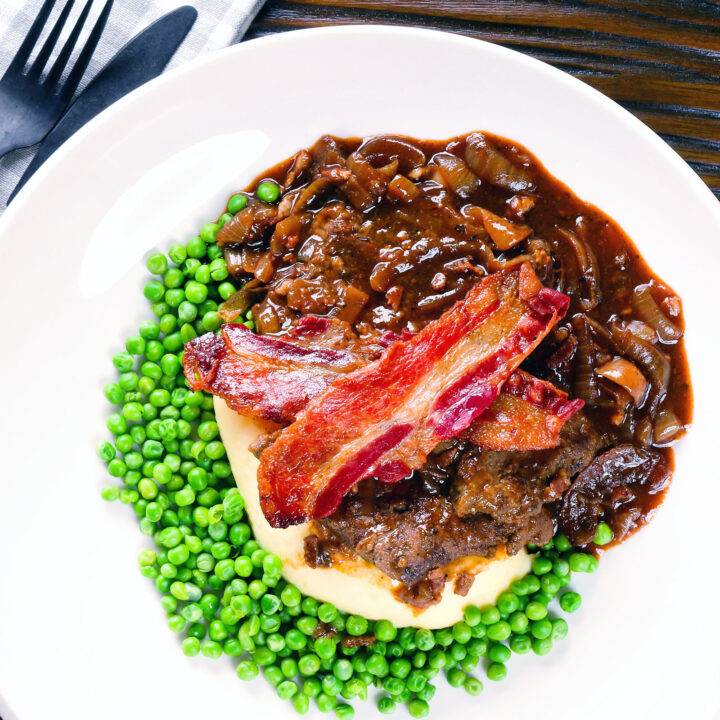 Braised liver and onions with onion gravy, crispy bacon, mashed potato and peas.