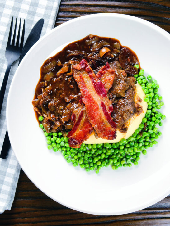 Overhead liver and onions, in onion gravy served with crispy bacon, mashed potato and peas.