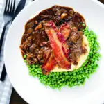 Overhead liver and onions, in onion gravy served with crispy bacon, mashed potato and peas.