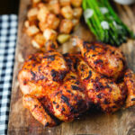 Whole baked peri peri spatchcock chicken served with Parmentier potatoes and garlic asparagus.