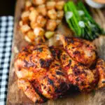 Whole baked peri peri spatchcock chicken served with Parmentier potatoes and garlic asparagus.