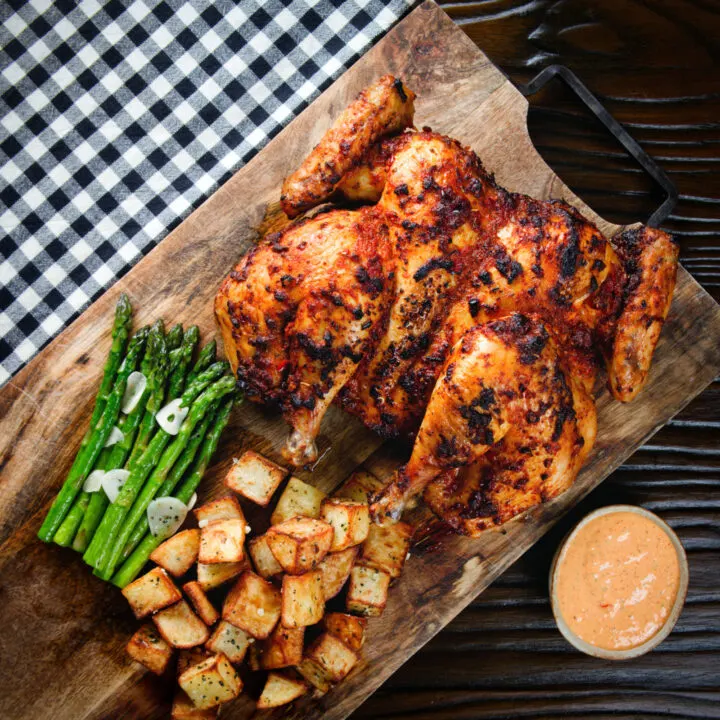 Whole roasted Spatchcock peri peri chicken with potatoes, asparagus and spicy mayonnaise.