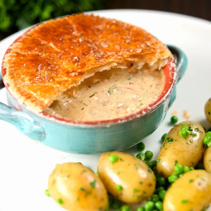 Pork belly and Bramley apple pot pi topped with puff pastry, served with peas and potatoes.