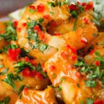 Close-up prawn and mango curry in a coconut milk sauce served with herby rice.