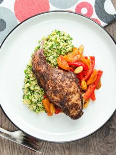 Overhead rabbit leg tagine served with herby bulgur wheat.