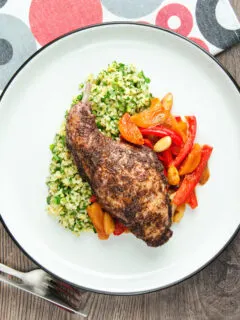 Overhead rabbit leg tagine served with herby bulgur wheat.