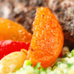 Close up dried apricot in a rabbit leg tagine.