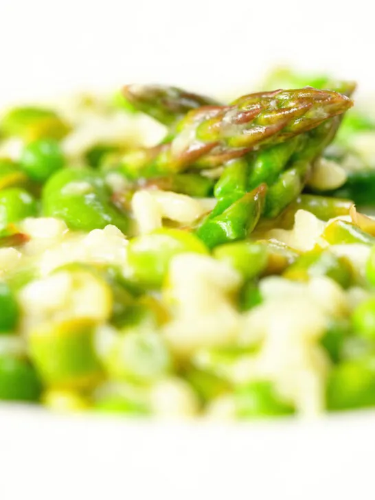 Close-up creamy spring broad bean, pea and asparagus risotto.