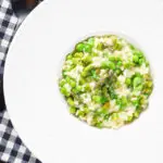 Overhead creamy spring broad bean, pea and asparagus risotto.